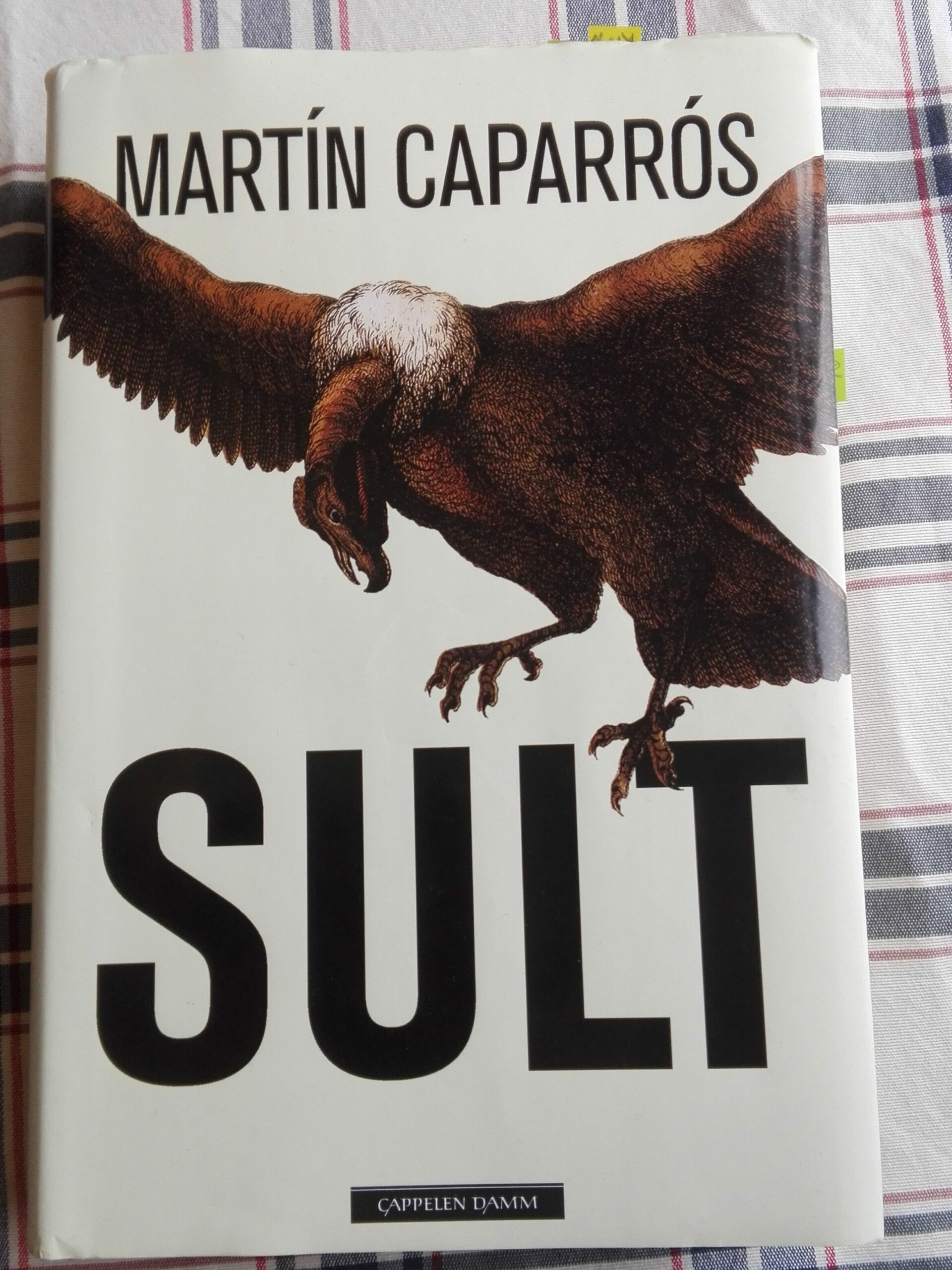 Fotografi av boka Sult av Martín Caparros. Omslaget viser en gribb.